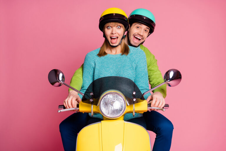 Photo of funny lady guy couple driving sitting big speed vintage yellow moped spend vacation, together open mouth wear casual jumper colorful headgear isolated pink color background